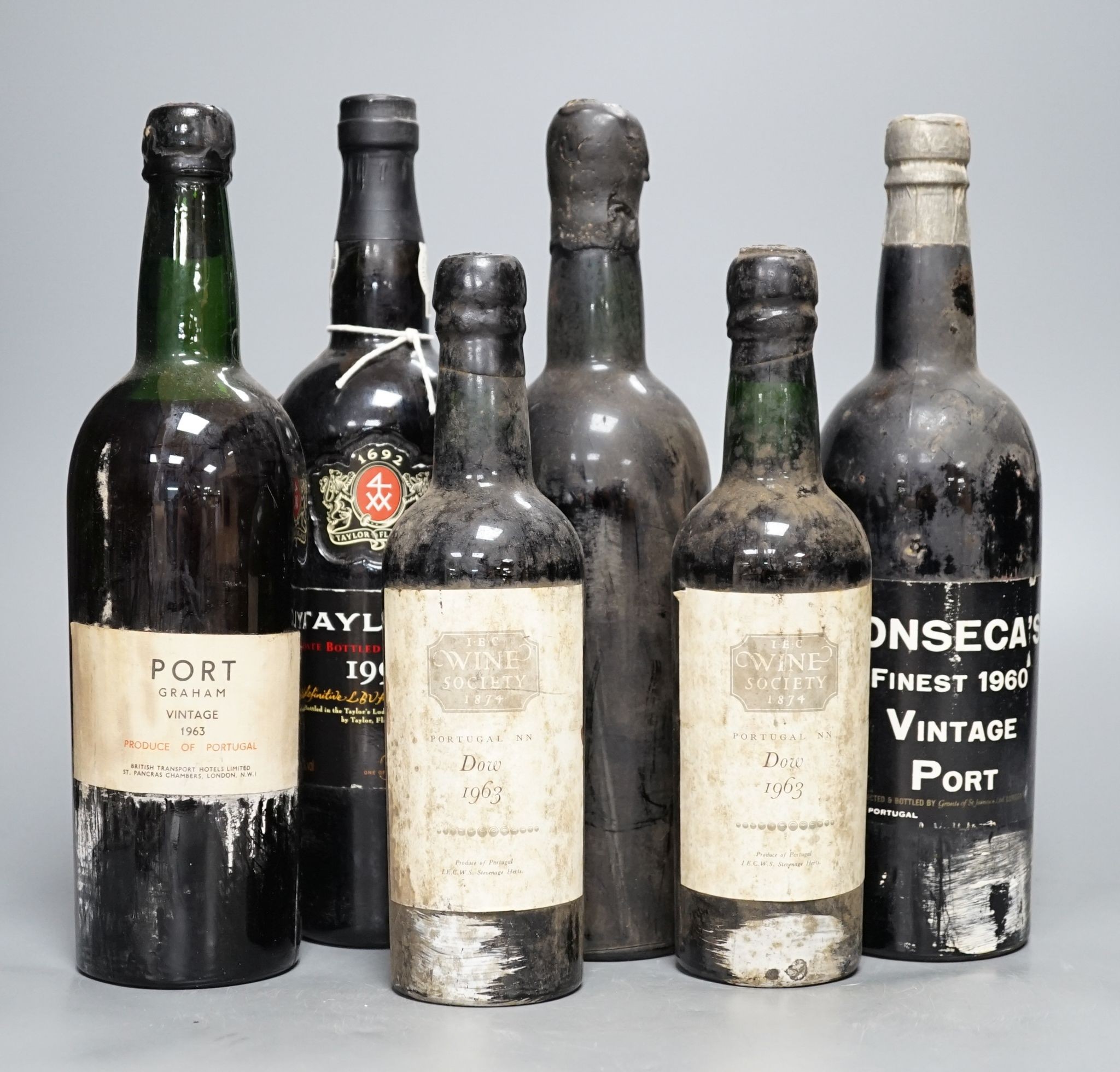 Four 75cl bottles of Port, Taylors 1997, Graham vintage 1963, Fonsescas 1960, another unlabelled, and two Dow, 1963